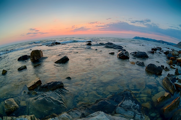 Coucher de soleil sur la côte avec des pierres