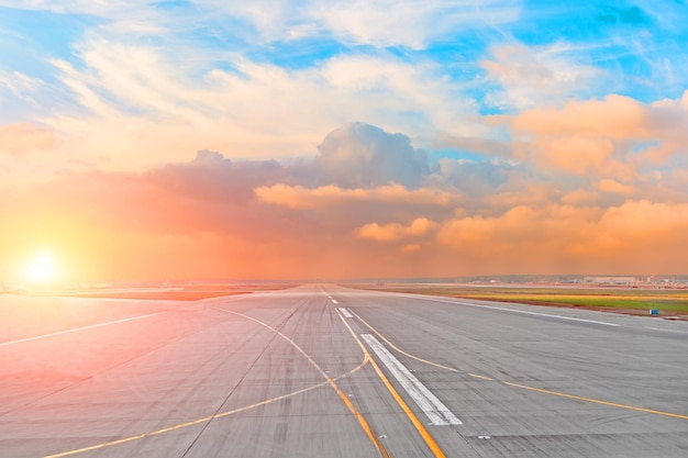 Coucher de soleil et cumulus sur la piste de route de l'aéroport