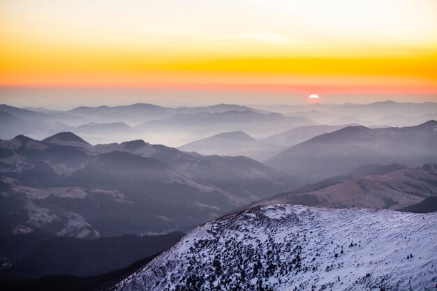 Coucher de soleil dans les montagnes d'hiver ciel orange dans les Carpates enneigées
