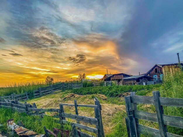 Le coucher de soleil dans le village Paysage rural avec une maison en bois