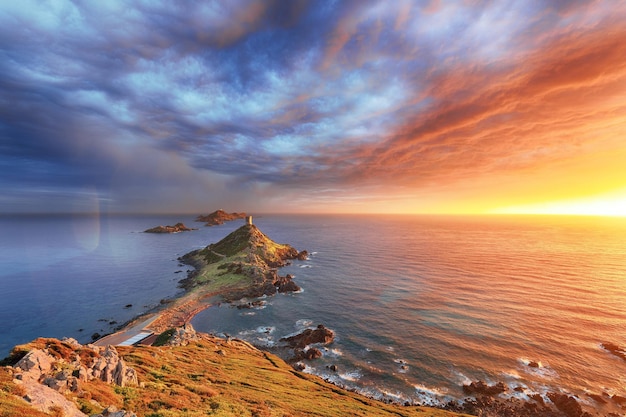 Le coucher de soleil sur la destination touristique populaire de Torra di a Parata avec la tour génoise et l'archipel des îles Sanguinaires en arrière-plan