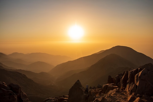 coucher de soleil doré entre brouillard et montagnes