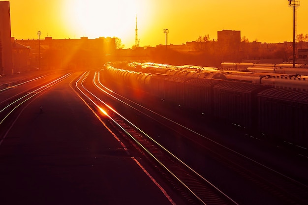 Le coucher de soleil écarlate à la gare le quai et les voitures