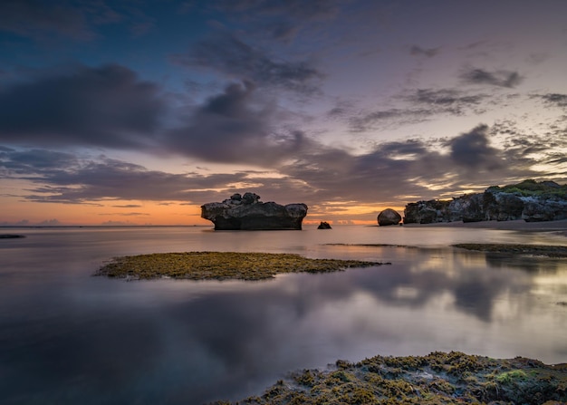 Un coucher de soleil à la formation rocheuse dans l'eau