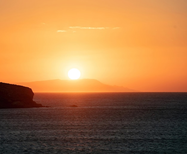 Coucher de soleil sur l'île grecque des Cyclades Grèce Soleil d'or colore le ciel Calme vaste mer Égée