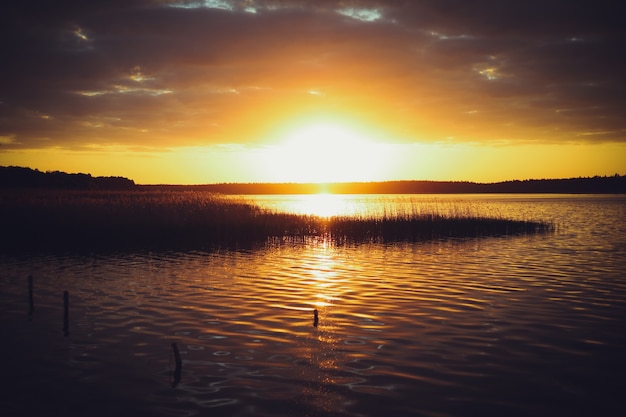 Photo coucher de soleil jaune sur le lac. arrière-plan naturel flou, ciel coucher de soleil sur le lac. baner nature silhouette