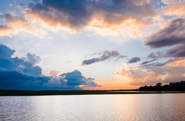 Coucher de soleil sur le lac Beau coucher de soleil derrière les nuages ​​au-dessus du paysage de lac backg