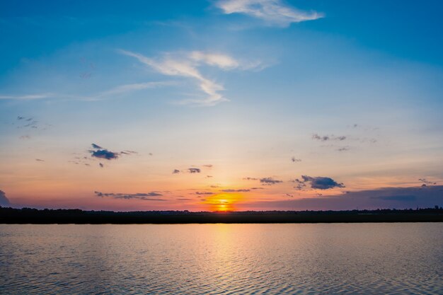 Coucher de soleil sur le lac beau coucher de soleil derrière les nuages ​​au-dessus du paysage de lac