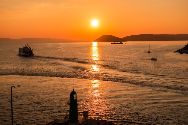 Coucher de soleil sur la mer Adriatique et ses bateaux jouant dans les reflets à l'entrée du port de Split en Croatie.