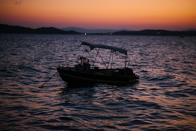 Le coucher de soleil sur la mer avec un bateau dans la ville d'Ouranoupolis Halkidiki Grèce