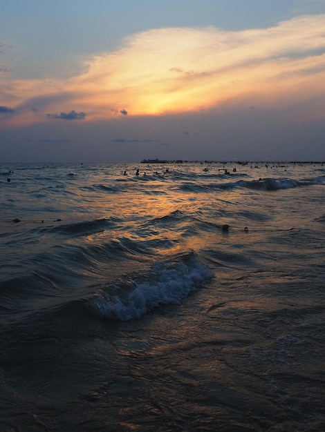 Coucher de soleil sur la mer Belles vagues au coucher du soleil Station balnéaire de la Mecque du tourisme Ciel du soir Les rayons se reflètent dans l'eau