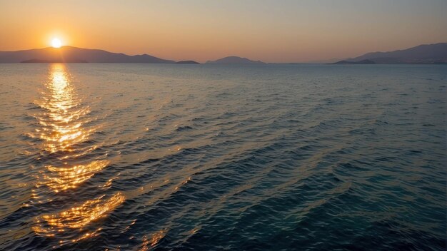 Le coucher de soleil sur la mer calme avec des nuages