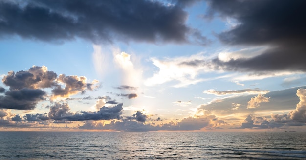 Coucher de soleil sur la mer avec ciel et soleil à travers les nuages sur le paysage marin de fond de ciel et d'océan