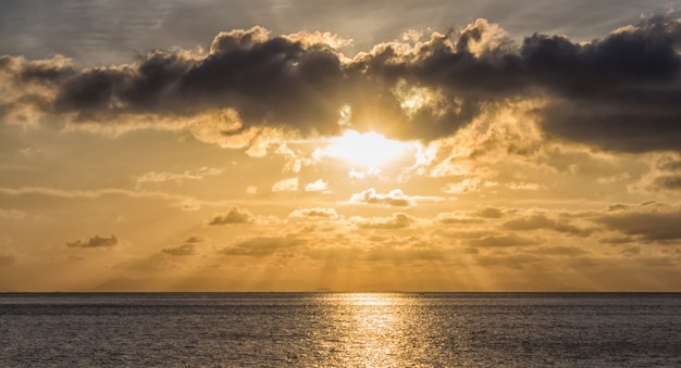 Coucher de soleil sur la mer avec les rayons du soleil à travers les nuages