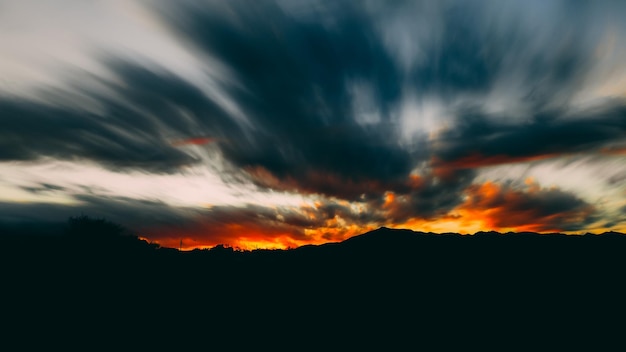 Un coucher de soleil avec une montagne en arrière-plan