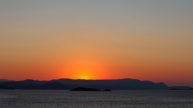 Un coucher de soleil sur les montagnes avec le soleil couchant derrière