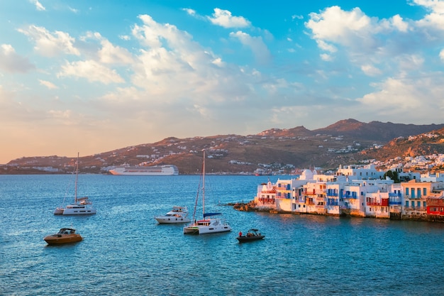 Coucher de soleil à mykonos en grèce avec bateau de croisière et yachts dans le port