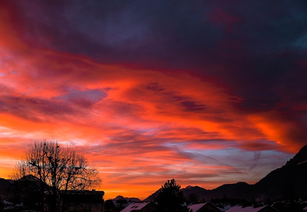 Coucher de soleil naturel Lever de soleil sur une ville Ciel dramatique lumineux et sol sombre Paysage de campagne sous un ciel coloré panoramique Soleil sur l'horizon Horizon Couleurs chaudes Coucher de soleil rouge