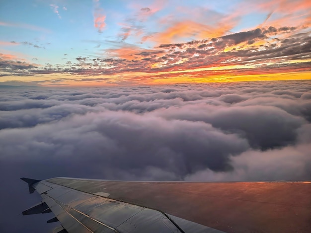 Le coucher de soleil sur les nuages avec l'aile d'un avion