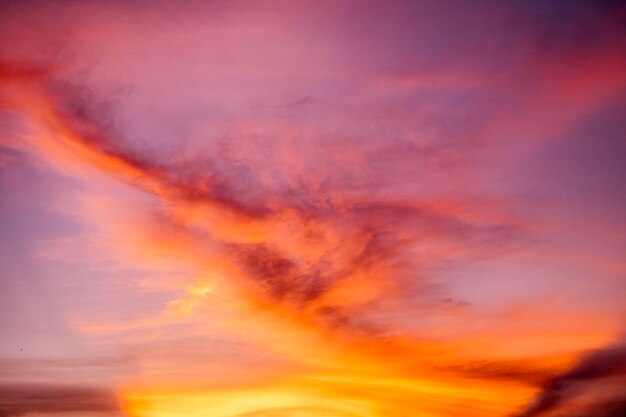 Un coucher de soleil avec des nuages et un ciel violet