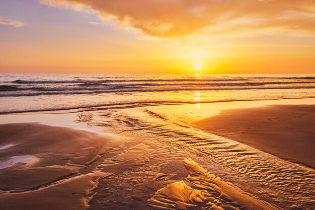 Coucher de soleil sur l'océan Atlantique avec des vagues déferlantes sur la plage de Fonte da Telha, Portugal