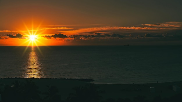 un coucher de soleil sur l'océan avec un bateau dans l'eau