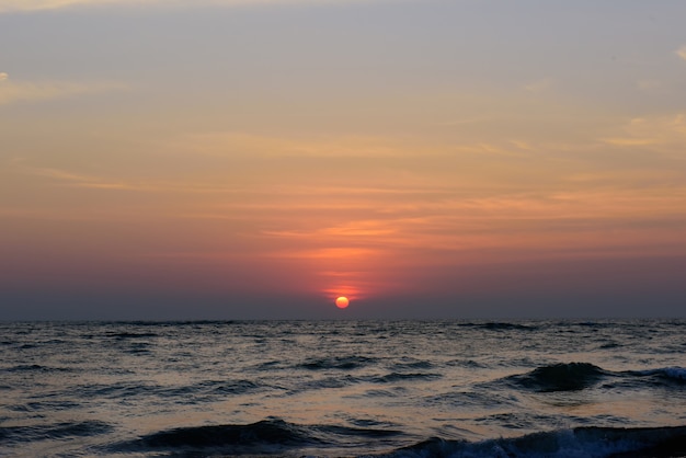 Coucher de soleil sur l'océan avec ciel nuageux