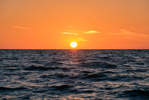 Coucher de soleil sur l'océan Grand soleil blanc sur fond de ciel lumineux spectaculaire nuage du soir doux sur l'eau sombre de la mer