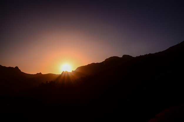 Coucher de soleil orange coloré derrière les montagnes