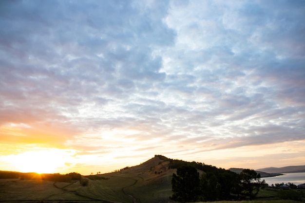 Coucher de soleil orange dans les montagnes près du lac en été