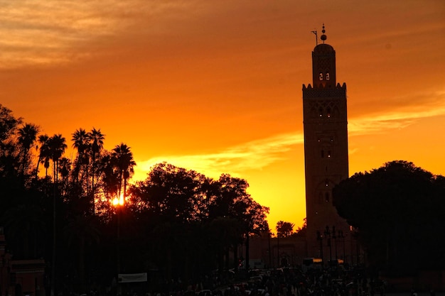 Coucher de soleil orange dans la tour de la place de Marrakech en arrière-plan Maroc