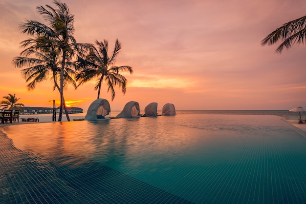 Coucher de soleil de piscine de luxe, silhouette de palmier avec surface d'eau de piscine à débordement venteuse. Vacances d'été