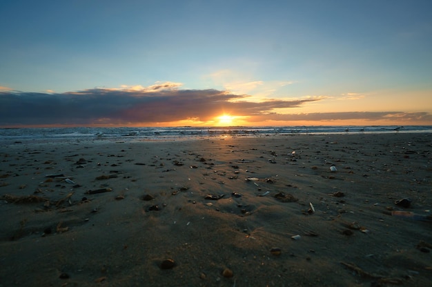 Coucher de soleil sur la plage au Danemark Coquillages au premier plan Promenade sur la côte