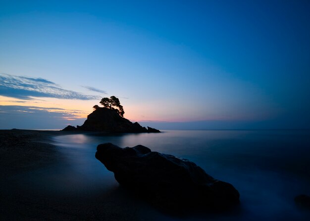 Coucher de soleil sur la plage avec quelques rochers