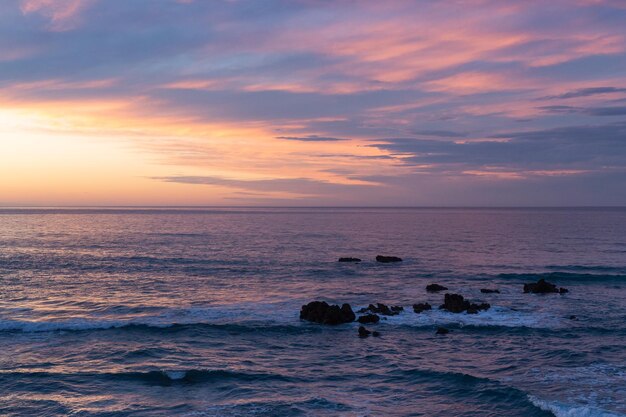 Coucher de soleil sur la plage avec des tons bleutés dans le ciel