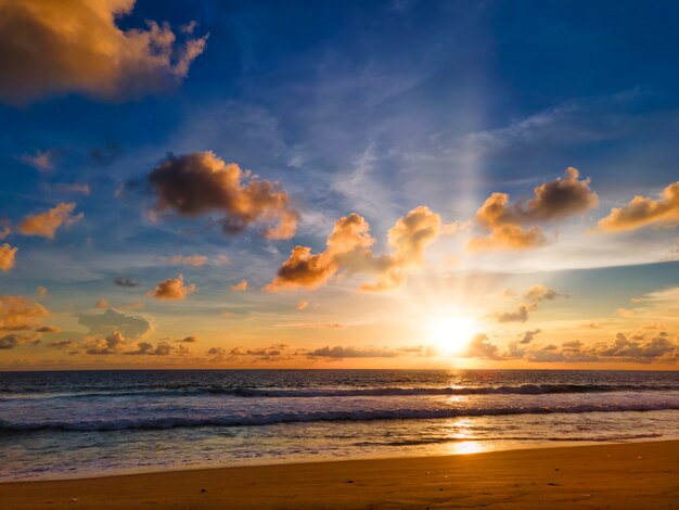 Coucher de soleil sur la plage tropicale colorée avec ciel jaune, bleu et rayon de soleil. coucher de soleil sur la mer à la plage de Phuket, Thaïlande.