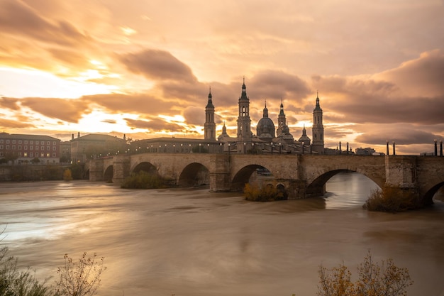 Coucher de soleil sur le Puente de Piedra à côté de la Basilique De Nuestra Senora del Pilar