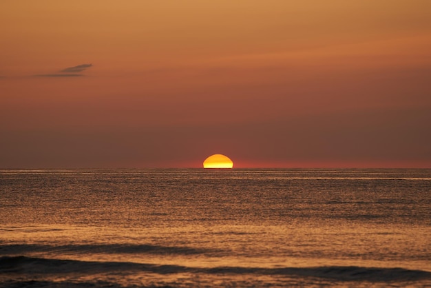 Coucher de soleil radieux sur l'océan Le soleil brillant se couche à l'horizon