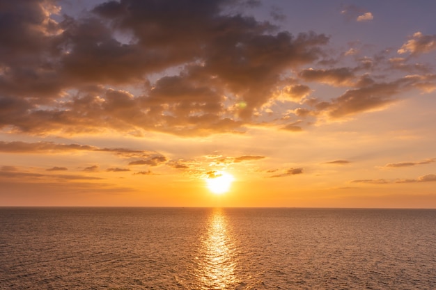 Coucher de soleil reflet océan. beau coucher de soleil derrière les nuages et le ciel bleu au-dessus de l'arrière-plan du paysage océanique