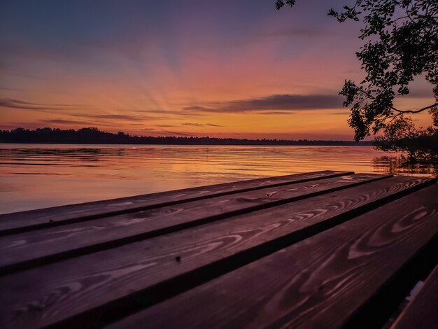 Coucher de soleil sur la rivière en été et jetée en bois