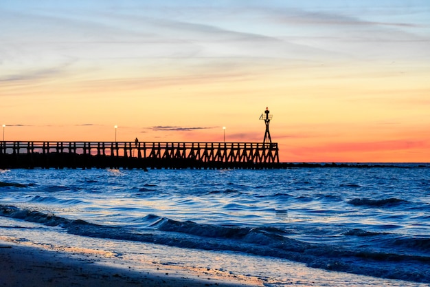 Coucher de soleil romantique et coloré au ponton de Courseulles-sur-Mer.