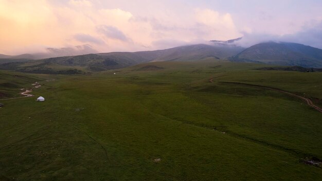 Photo le coucher de soleil rose dans les montagnes avec des champs verts