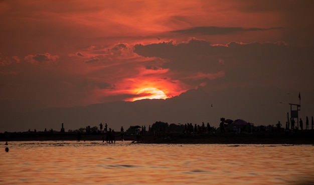 coucher de soleil rouge ardent sur la plage, vue depuis la mer