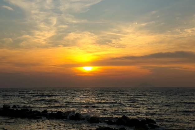 Coucher de soleil spectaculaire dans les nuages sombres au-dessus de la mer