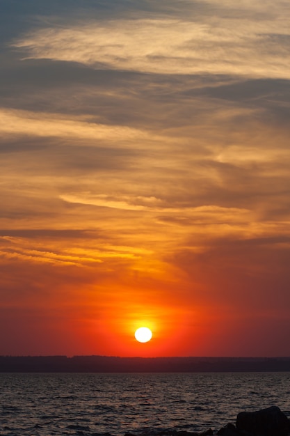 Coucher de soleil spectaculaire sur la mer. le soleil couchant sur le ciel rouge