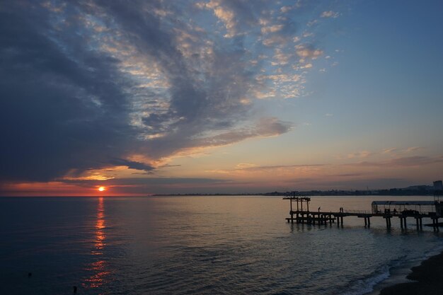 un coucher de soleil spectaculaire avec des nuages sombres sur la mer calme