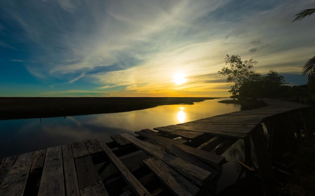 Un coucher de soleil spectaculaire avec une rivière et un arbre