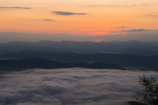 coucher de soleil surplombant les montagnes avec brouillard