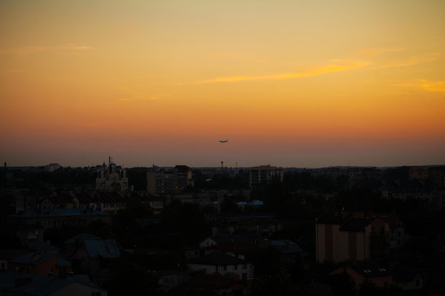 Coucher de soleil sur une ville, le ciel est coloré et plein de nuages.