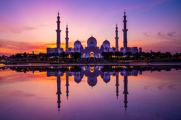 Coucher de soleil violet magique de la Grande Mosquée d'Abu Dhabi le soir au coucher du soleil. Panorama de l'extérieur de la mosquée Sheikh Zayed aux Émirats arabes unis.